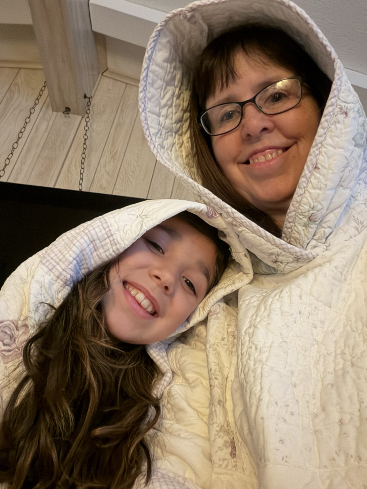 Sharlene and child wearing matching cream quilted hoodies with floral patterns
